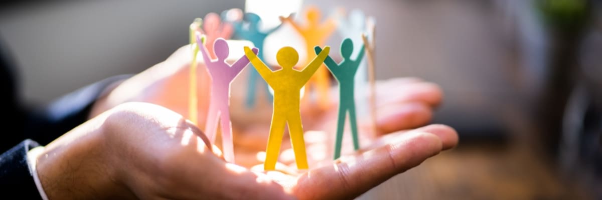Human Resource Person holding a paper cut-out of people, representing the importance of employment law enforcement.