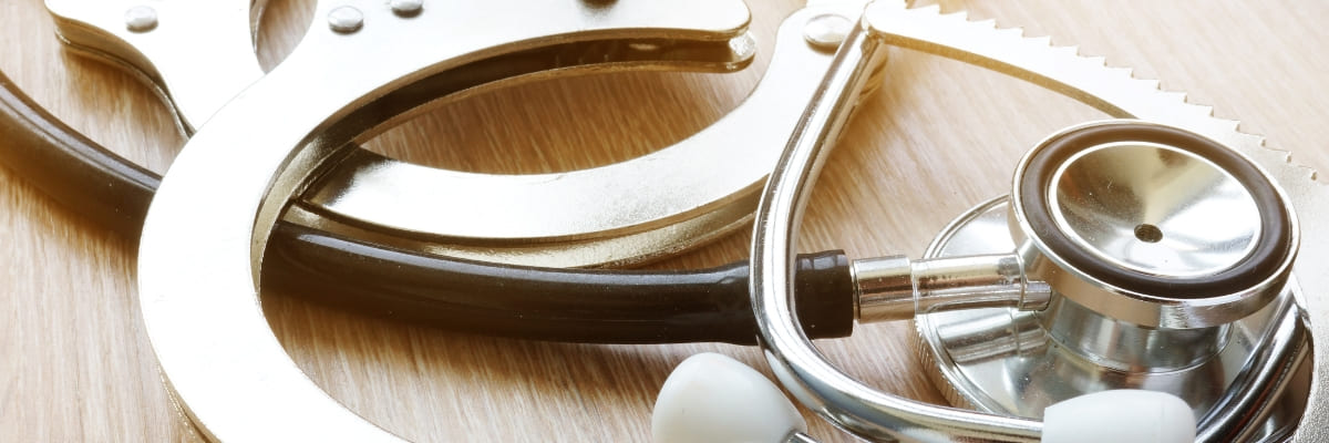 Handcuffs and stethoscope representing medical negligence claim